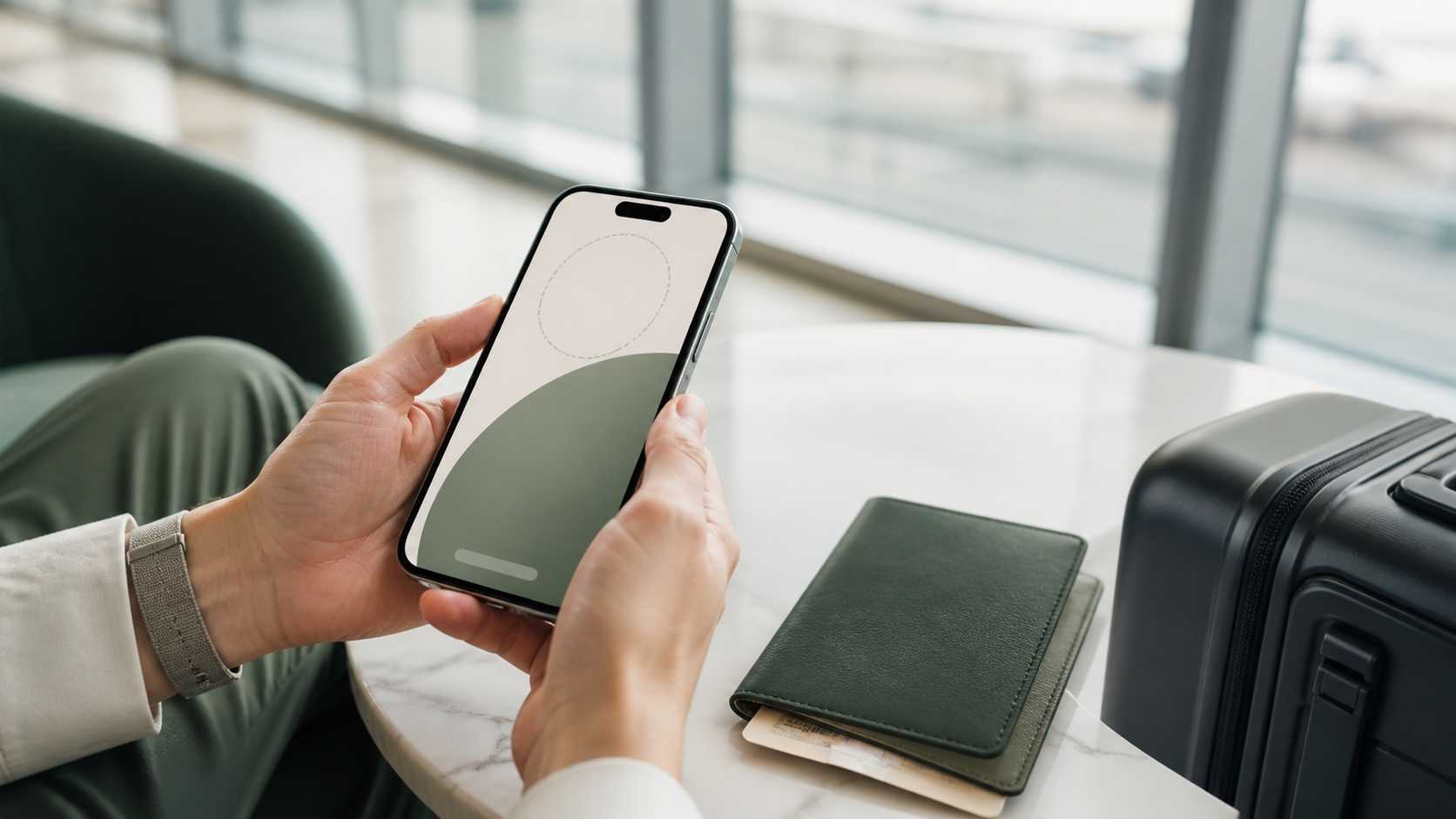 Traveller setting up an eSIM on a smartphone beside a carry-on bag